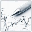 A pen sits atop financial charts