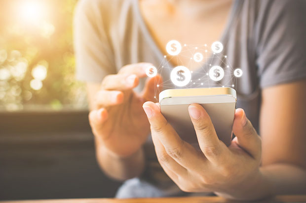 A woman uses a cell phone to make a payment.