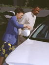 Photograph of two people looking at a car